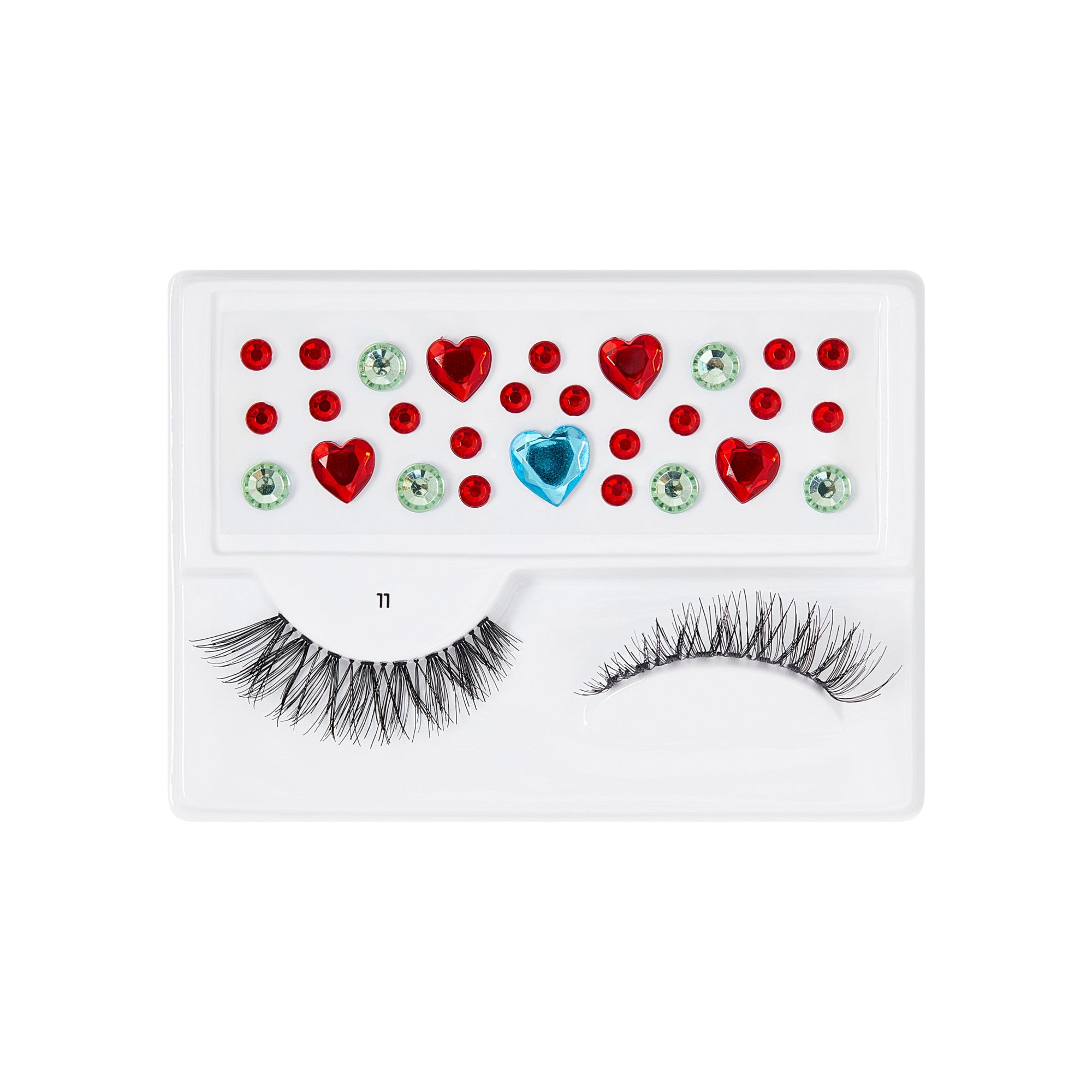 The image features a makeup accessory set that includes a pair of false eyelashes and decorative gems. The eyelashes are styled with a dramatic, feathery look, while the accompanying gems are arranged in a playful pattern. The gems include red hearts, green circular shapes, and a blue gem, all set against a white background. This combination creates a vibrant and fun aesthetic, perfect for adding flair to makeup looks.