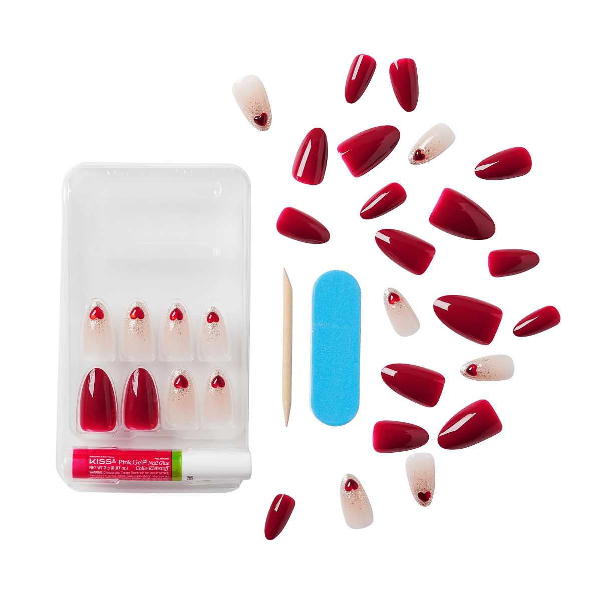 Set of artificial press-on nails in glossy deep red and ombre nude with red heart and glitter accents, displayed with nail glue, wooden cuticle stick, and blue nail file.