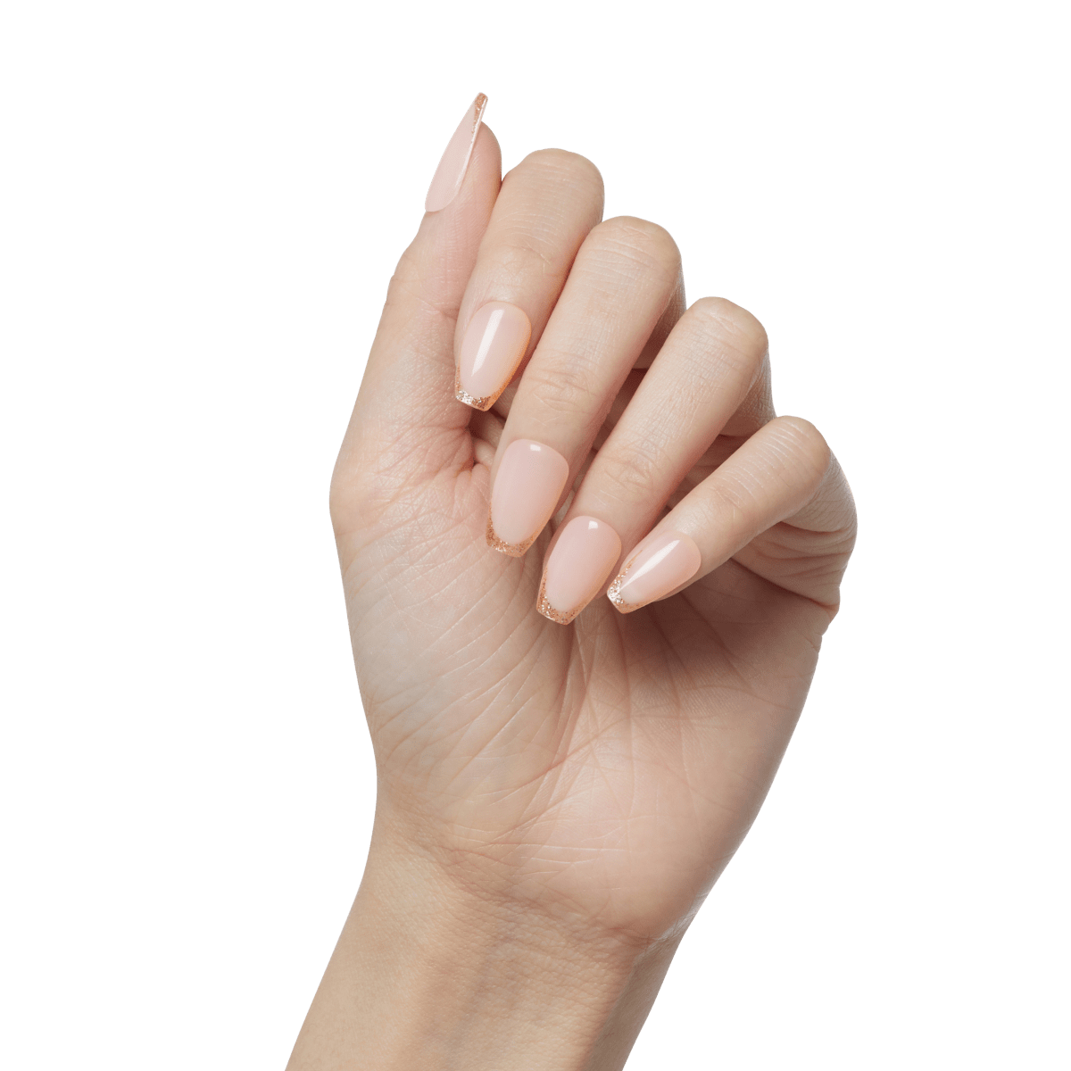 Hand with long almond-shaped press-on nails in a nude pink shade with subtle glittery rose gold tips, shown against a plain background.