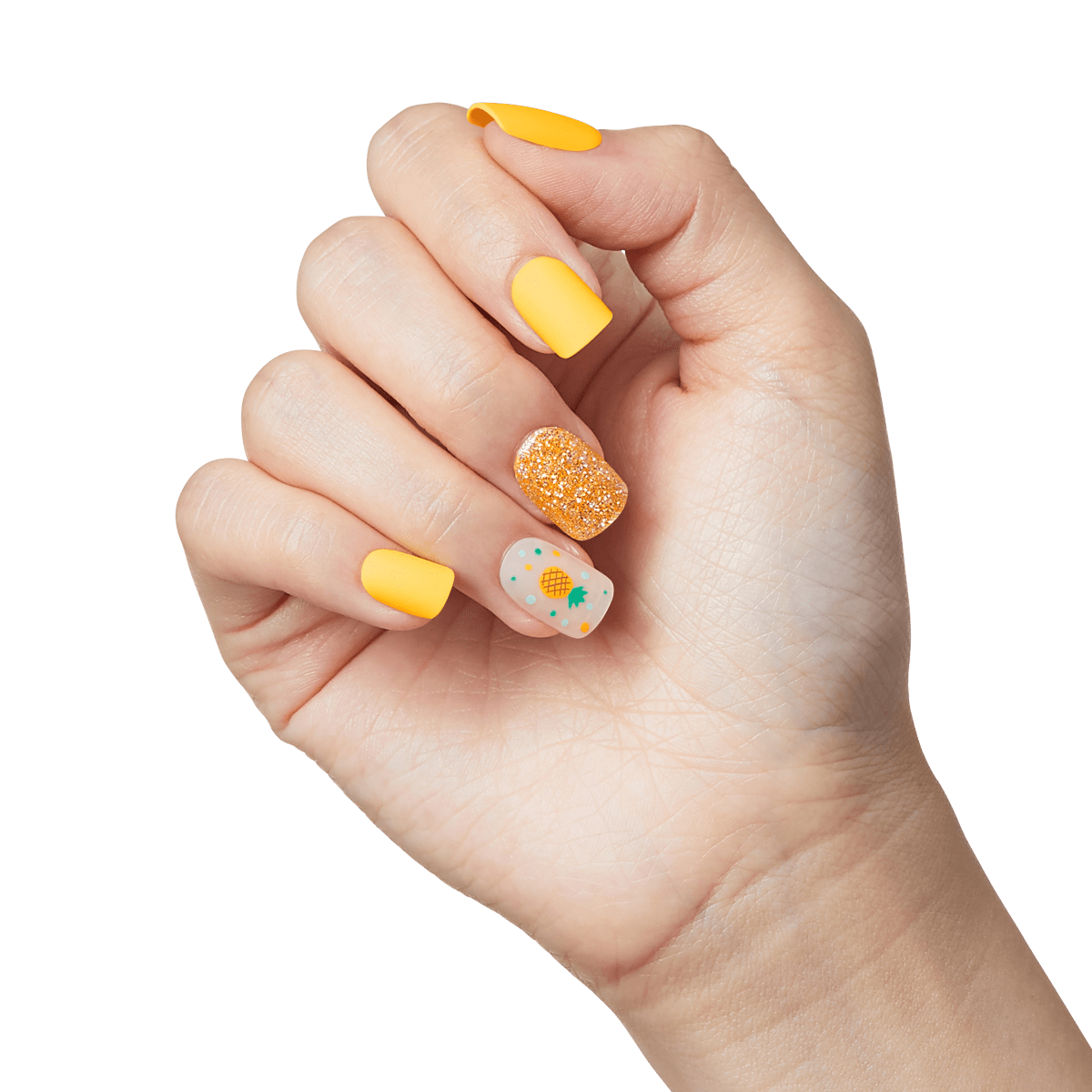 Hand with press-on nails in bright yellow, orange glitter, and a neutral accent nail featuring a small pineapple and colorful dots design.
