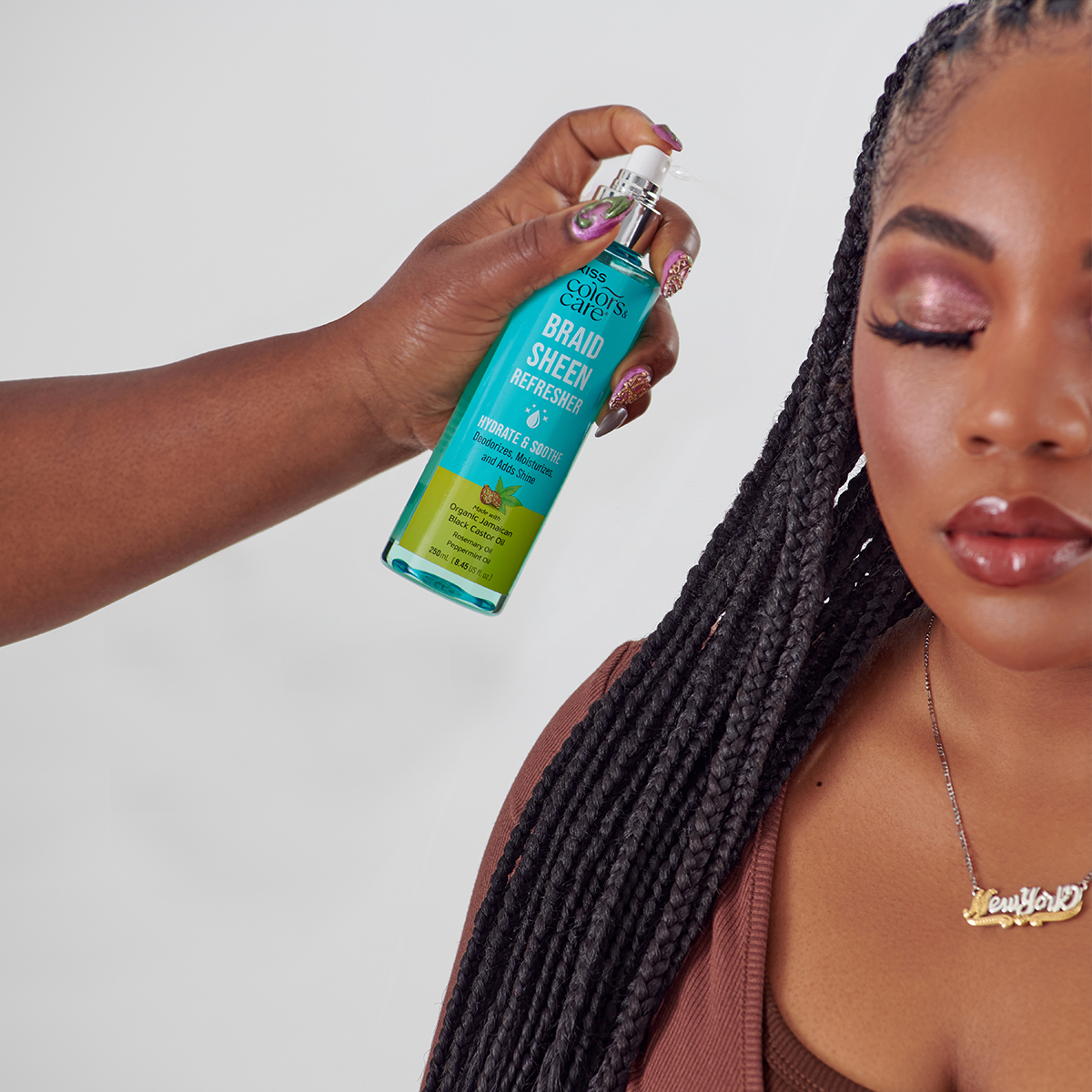 Hand holding and spraying turquoise bottle labeled \