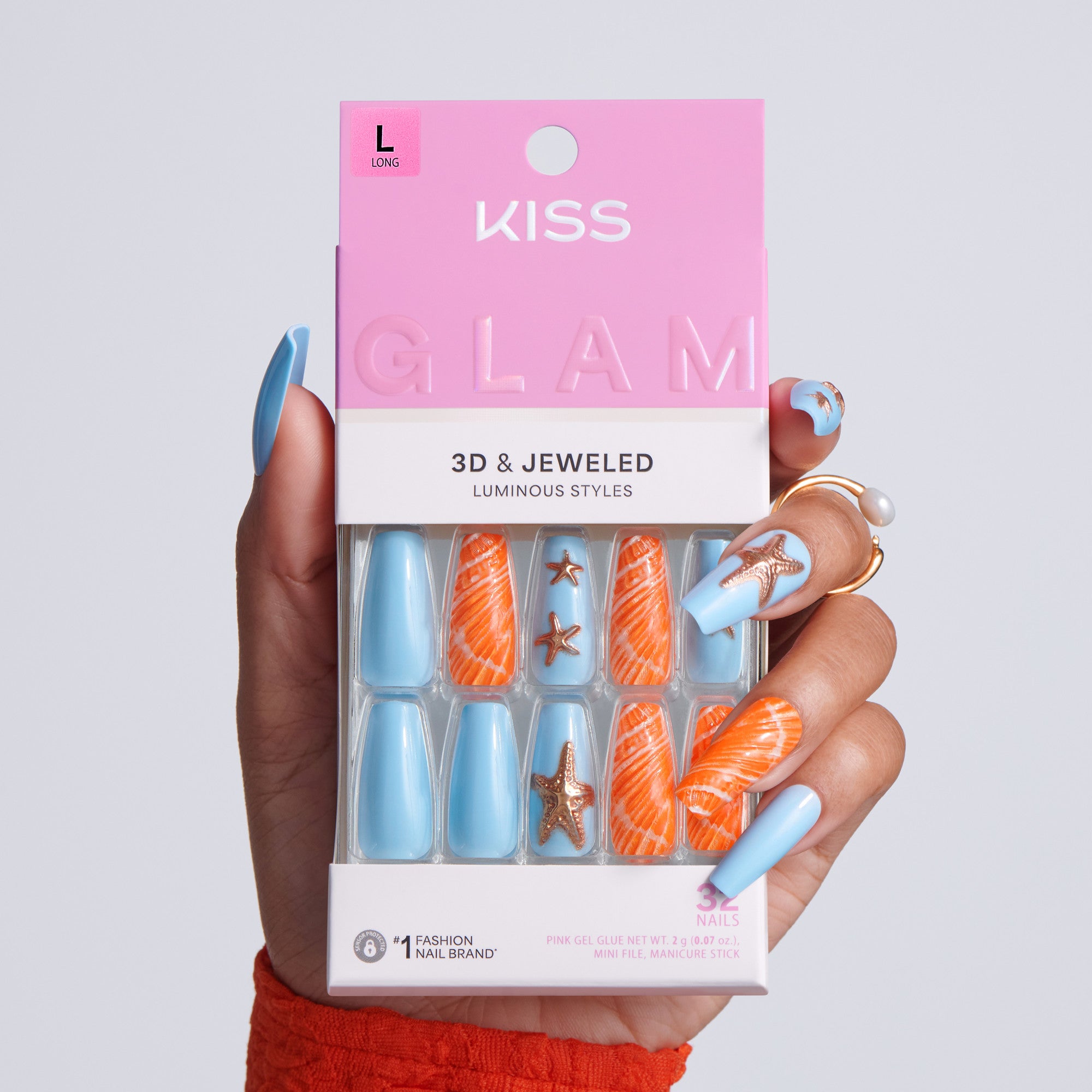 Kiss Glam 3D & Jeweled nail art set held by a hand with blue and orange nail designs.