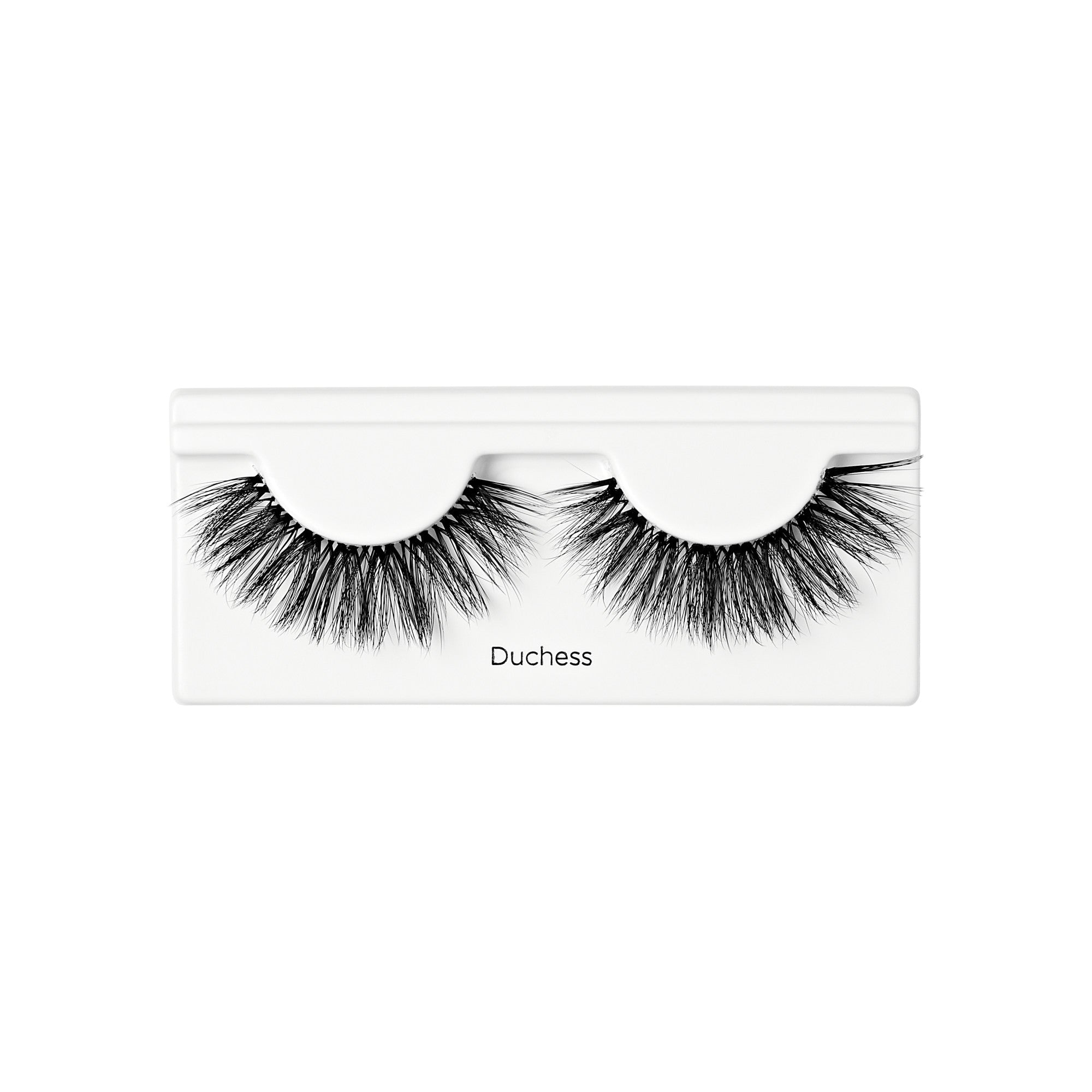 Pair of black, voluminous false lashes with layered, wispy fibers displayed on white tray labeled \