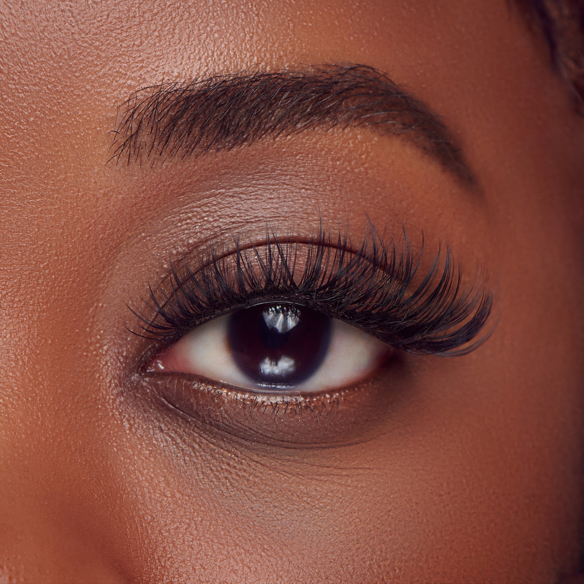 The image features a close-up of a human eye, showcasing long, voluminous eyelashes that enhance the eye&