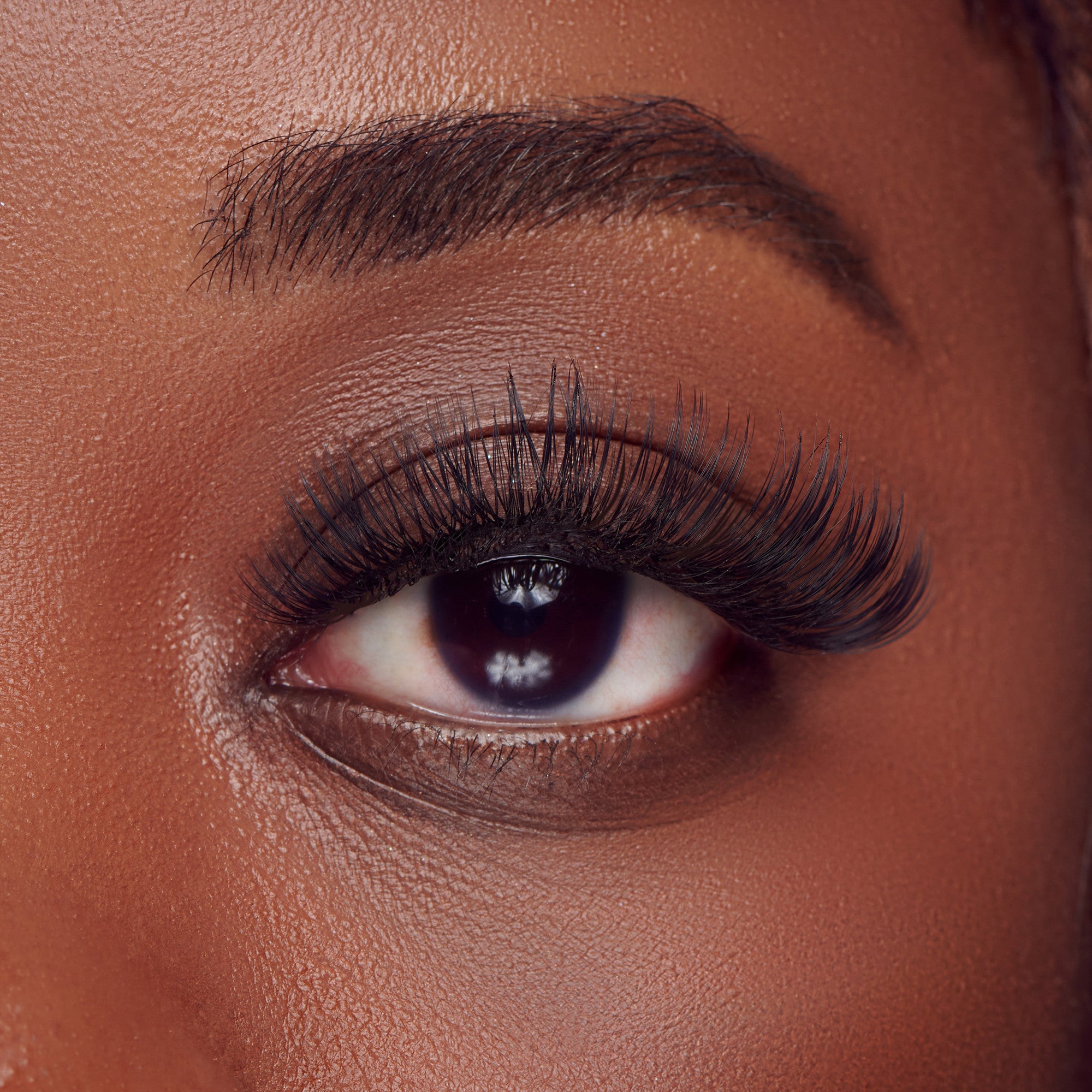 The image features a close-up of a human eye, showcasing long, dramatic eyelashes that enhance the eye&