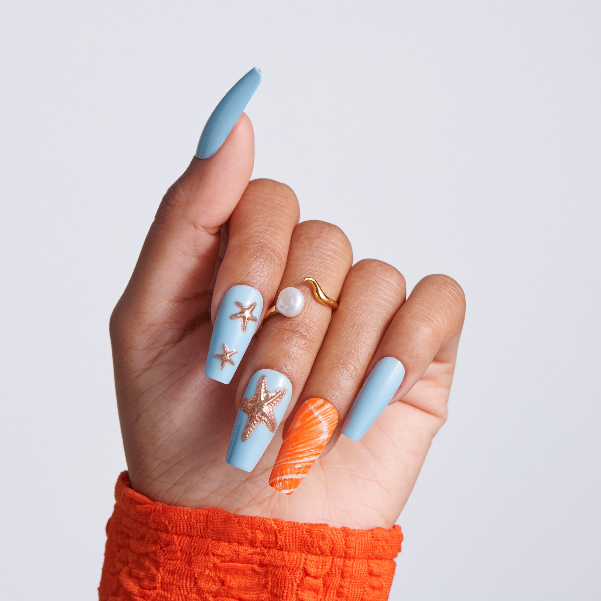 Hand with blue and orange nail art on a plain background