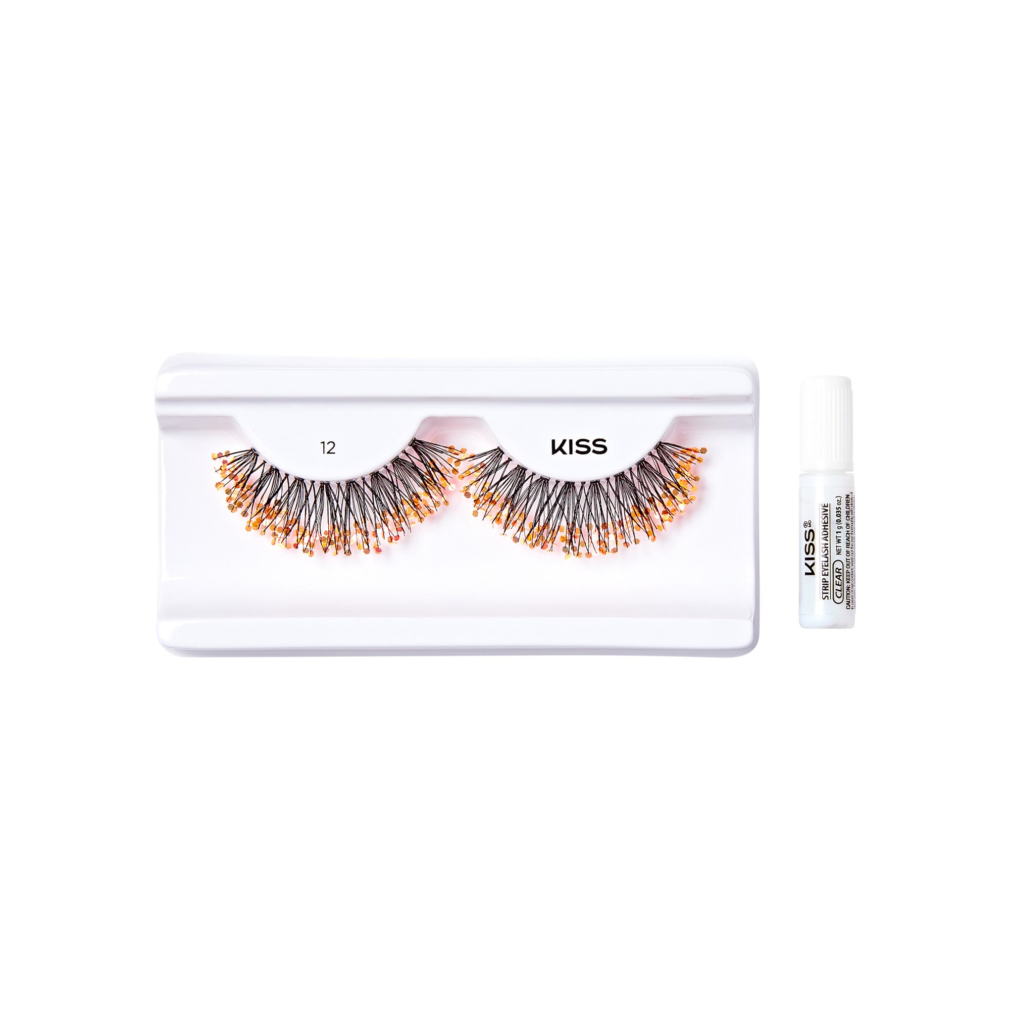 The image shows a set of false eyelashes from the brand "KISS." The eyelashes are displayed in a white plastic tray with two compartments, each holding one eyelash. The eyelashes are voluminous and appear to have a mix of black and orange colors. To the right of the tray, there is a small white tube of adhesive, also branded with "KISS," which is used to apply the eyelashes. The tray and adhesive are placed on a plain white background.