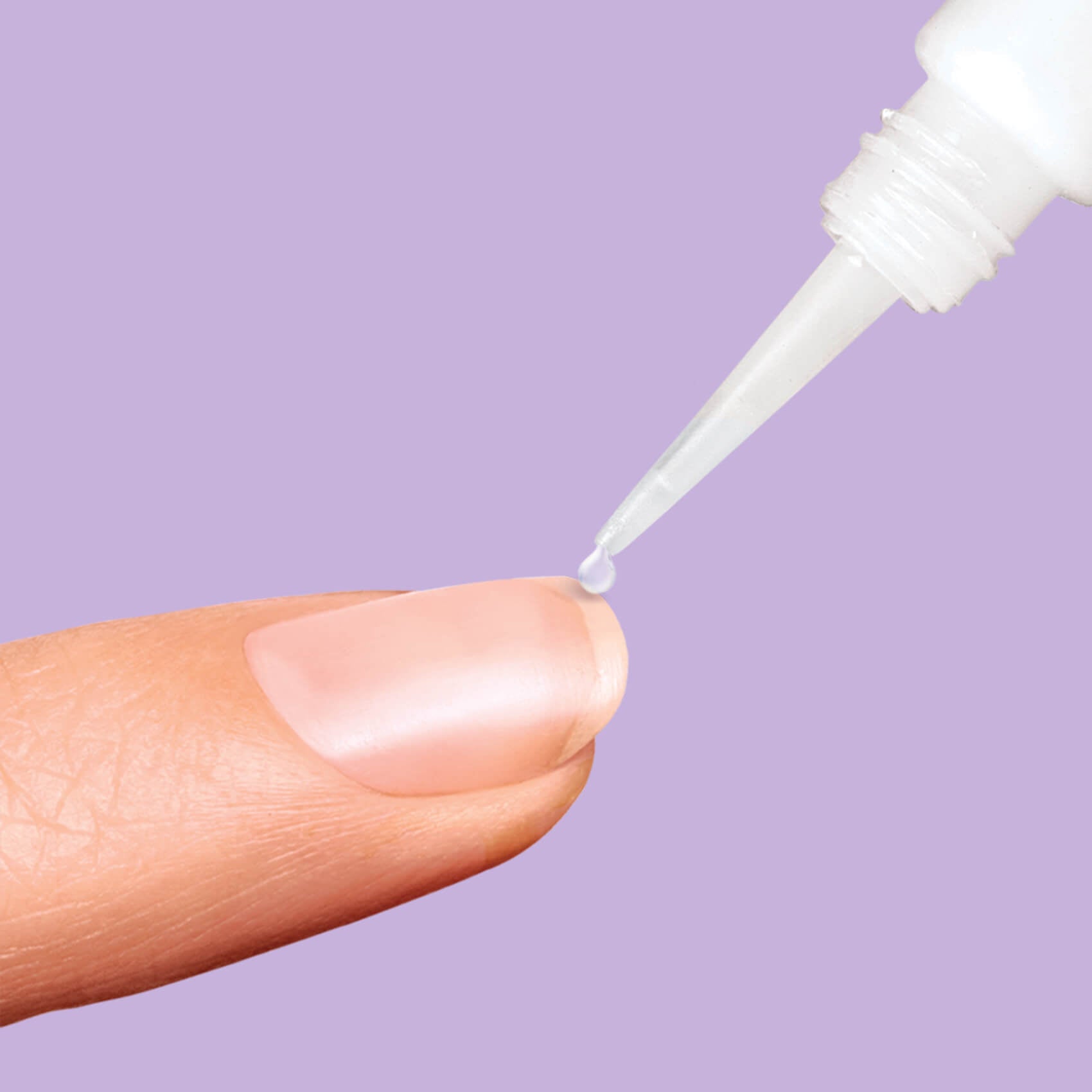 A close-up of a fingertip with clear nail glue being precisely applied from a white applicator tip against a solid lavender background.
