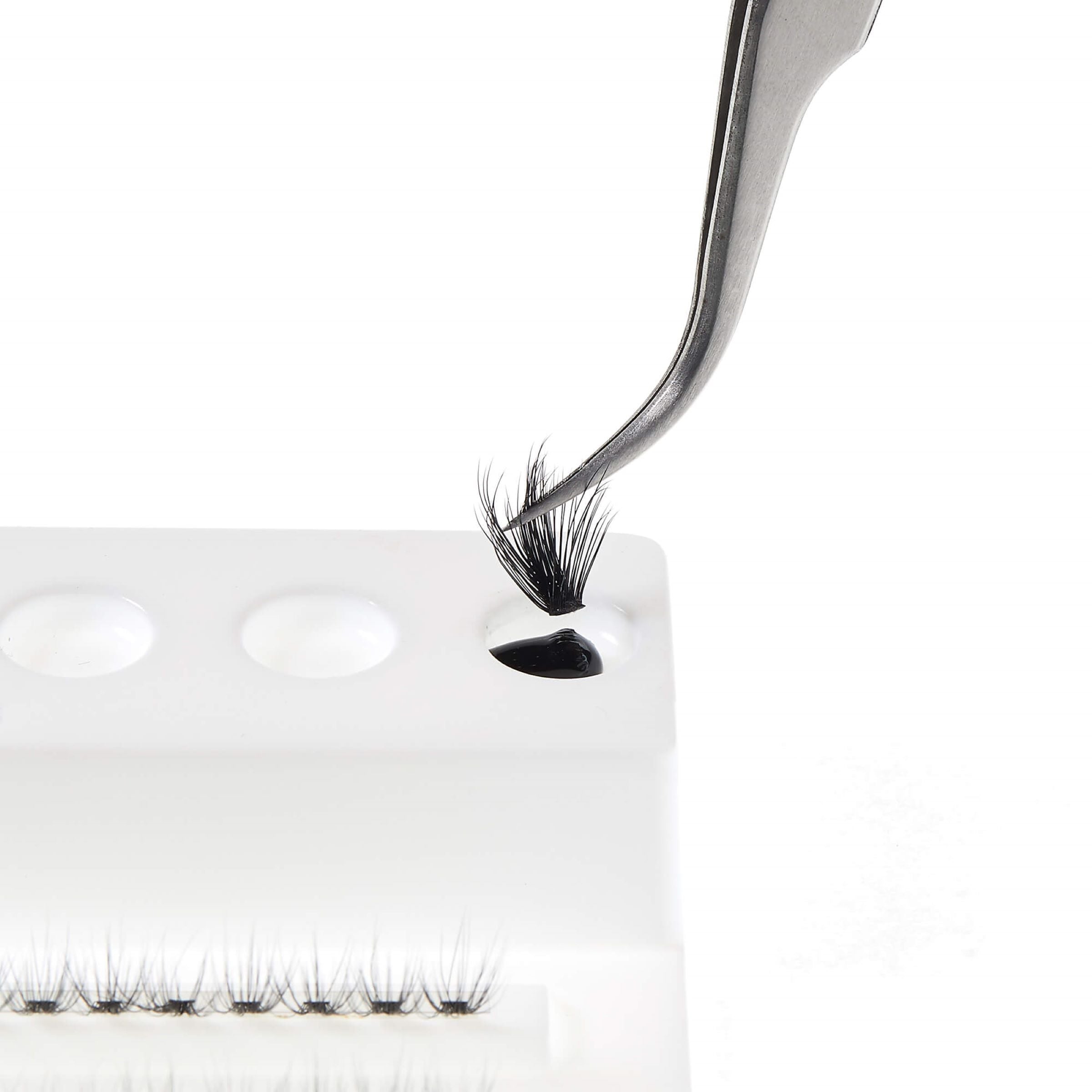False eyelashes with a pair of tweezers on a white background