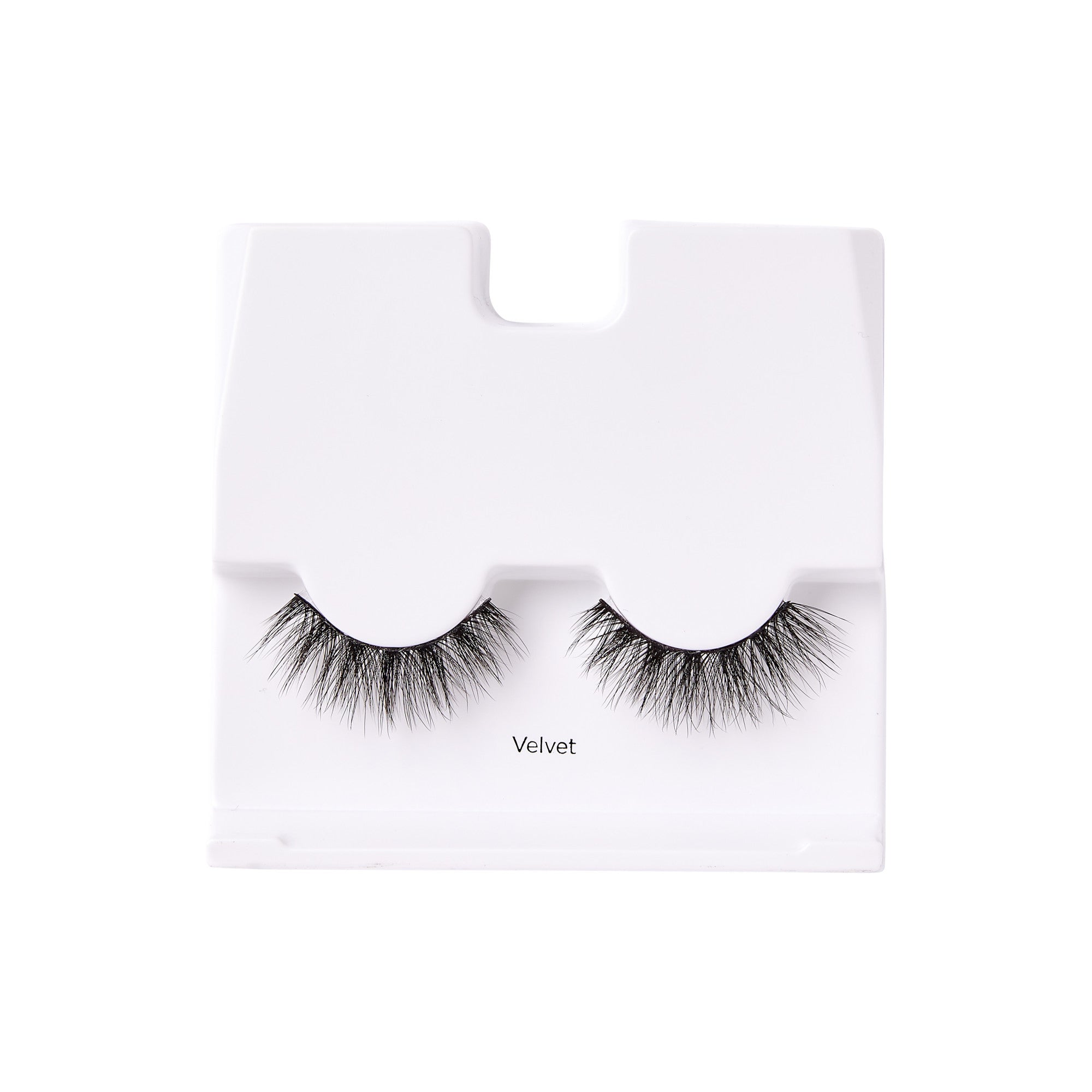 Pair of black false eyelashes with a full, fluffy texture displayed on a white tray labeled \