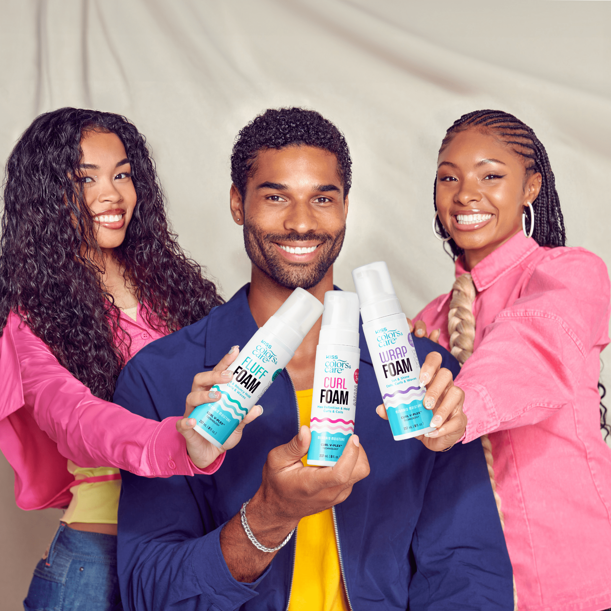 Three people holding Colors & Care Curl Foam hair products against neutral background.