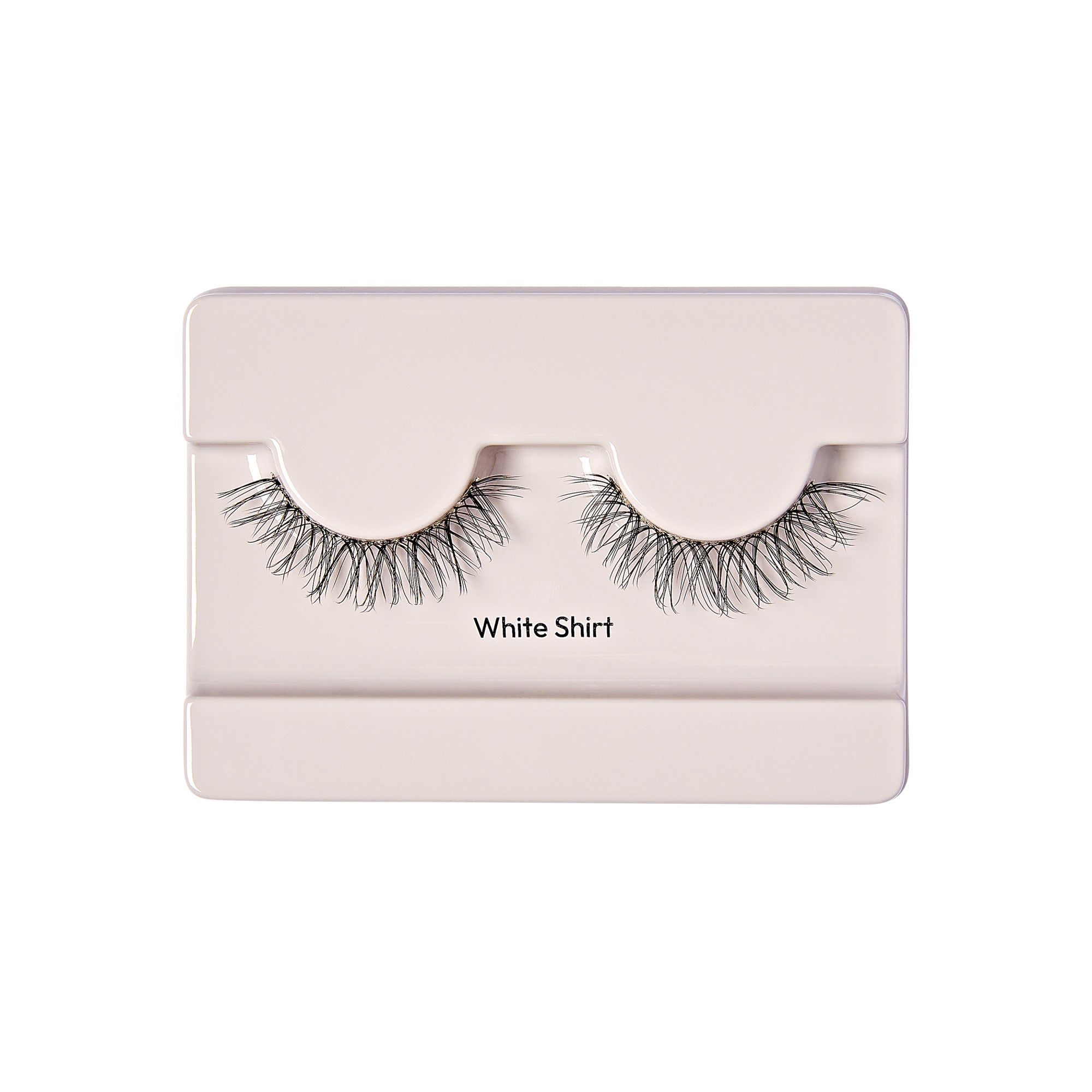 The image shows a pair of false eyelashes displayed in a light-colored packaging. The packaging is simple and rectangular, with a slot to hold each eyelash securely in place. The eyelashes are long and voluminous, with a natural-looking curl. The text "White Shirt" is printed on the packaging below the eyelashes.