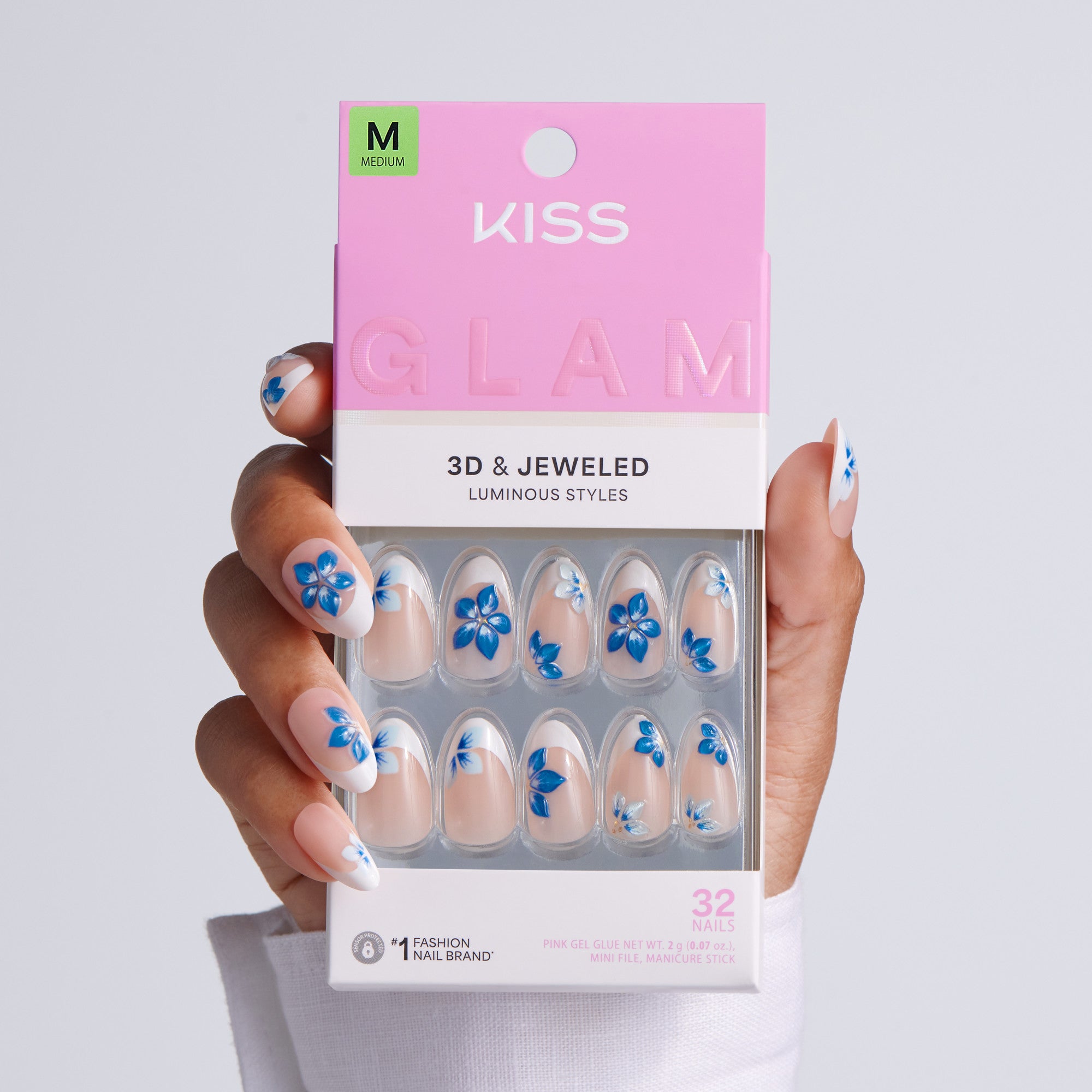 Kiss Glam 3D & Jeweled nail packaging held by a hand with matching nail designs.