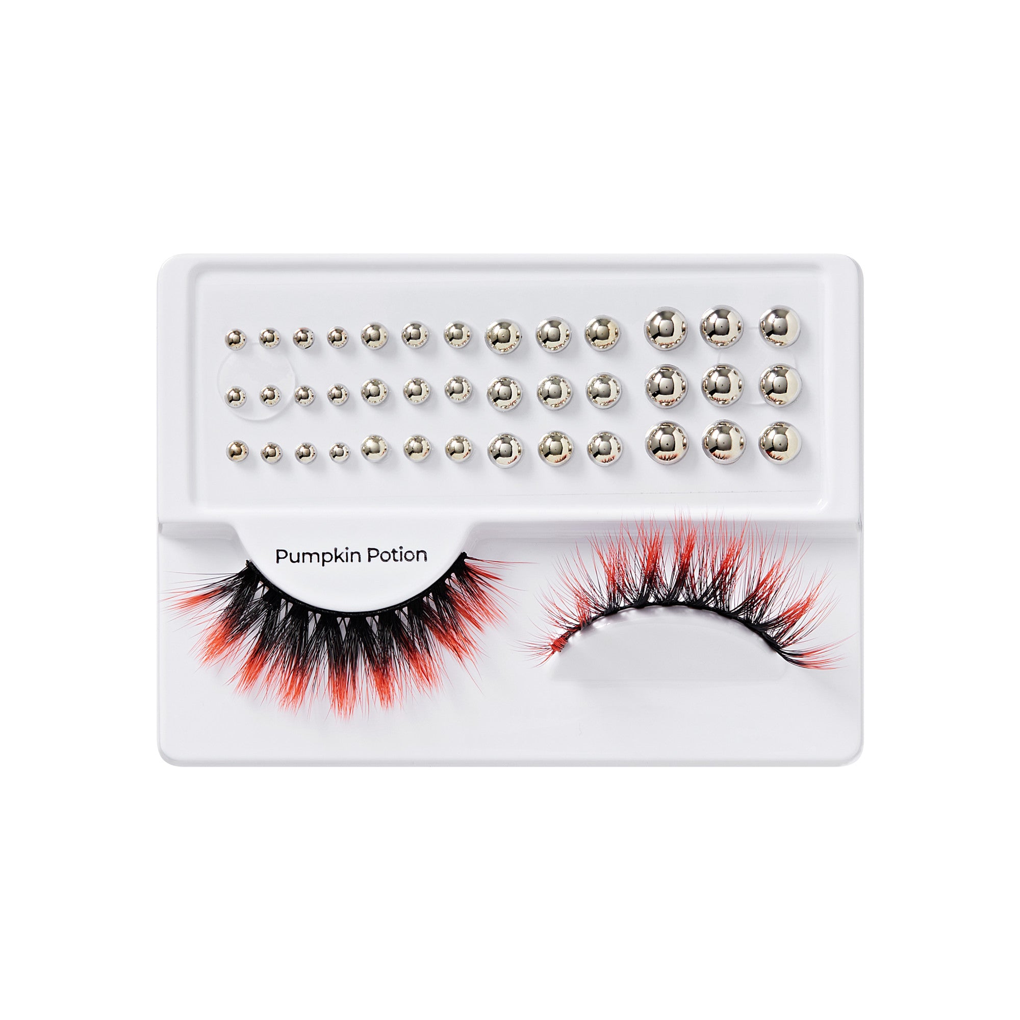 False eyelashes with black and orange tips are paired with rows of metallic silver gem stickers in various sizes on a white tray labeled \