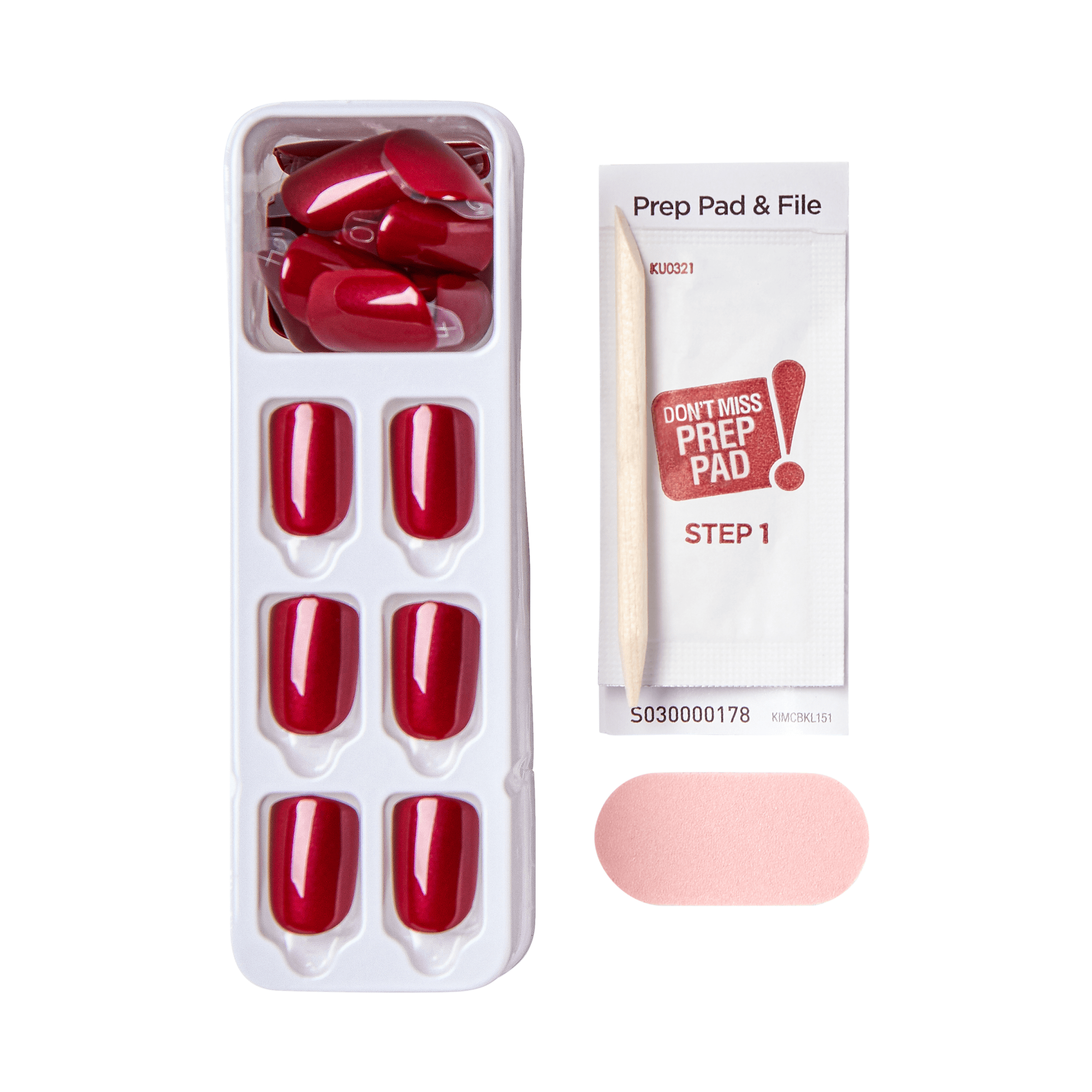 Tray of glossy red press-on nails in various sizes, accompanied by a wooden cuticle stick, a pink nail file, and a prep pad packet labeled \
