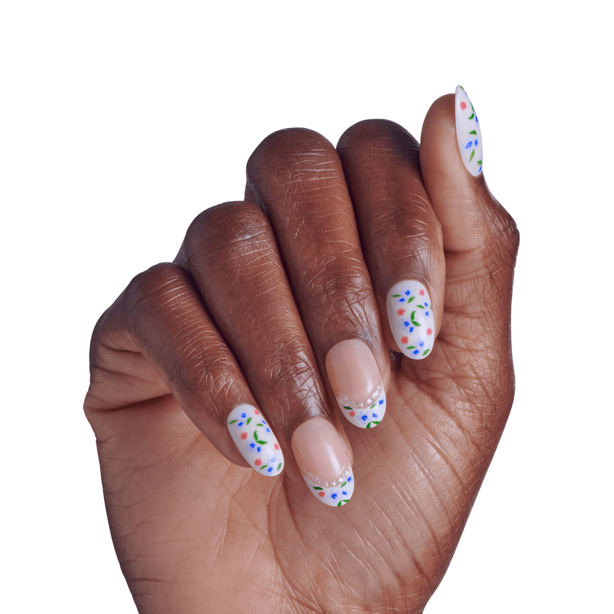 Hand displaying manicure with white oval nails and colorful floral nail art design.