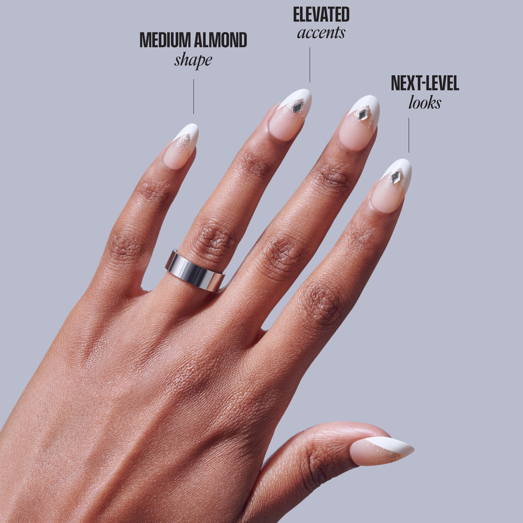 Manicured hand displaying medium almond nails with white tips and metallic accents.