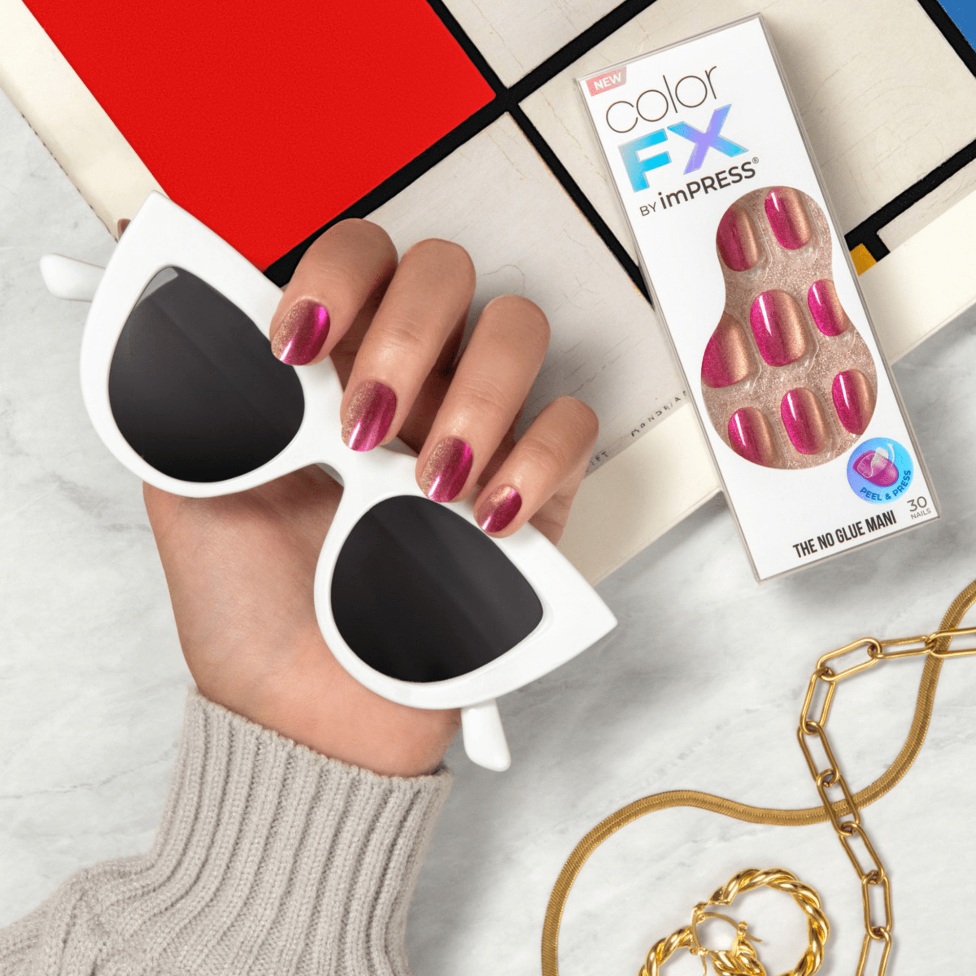 Hand wearing press-on nails in metallic pink and rose gold holding white cat-eye sunglasses, next to colorFX by imPRESS packaging showing the same nail design and labeled \