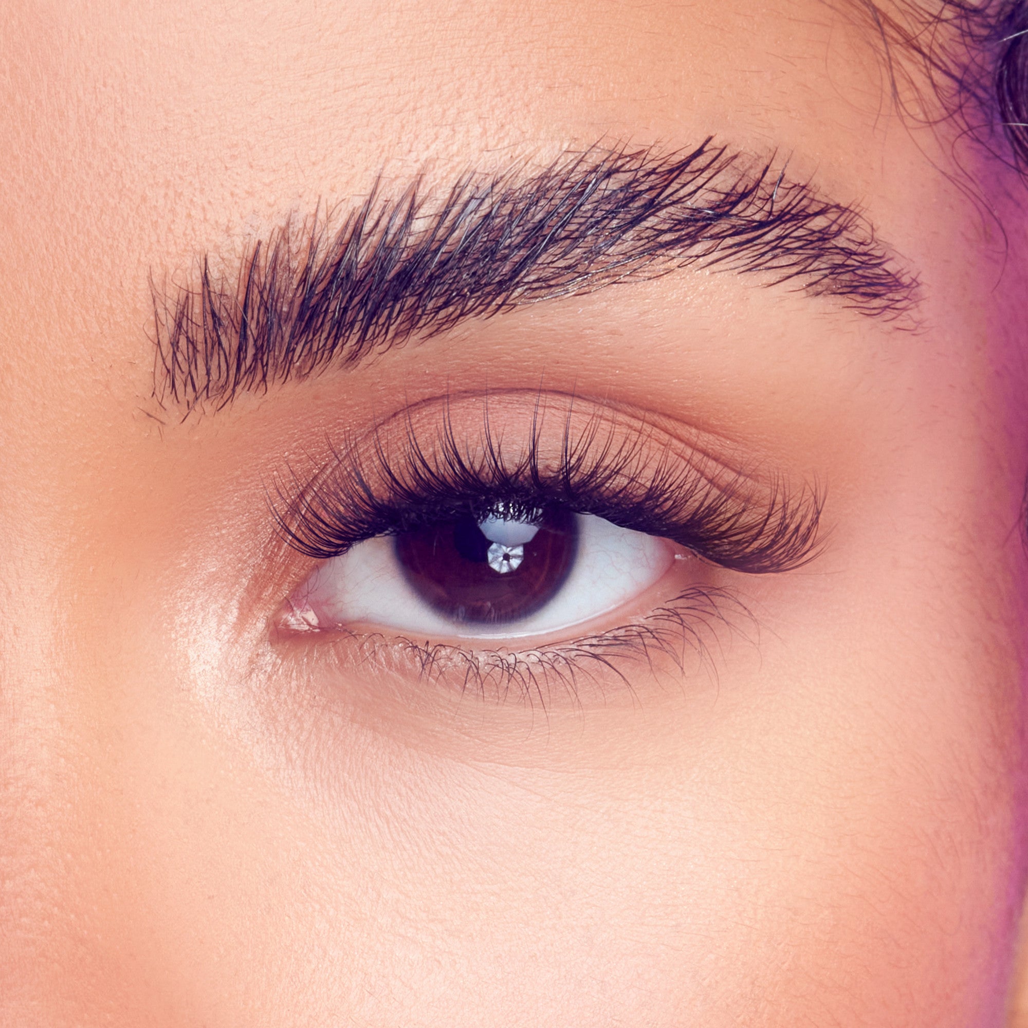 Close-up of a brown eye with long, thick, and curled false eyelashes applied, highlighting the natural yet voluminous lash effect of the FALSCARA Studio Lash Palette Xtra Fluffy 18 Wisps.
