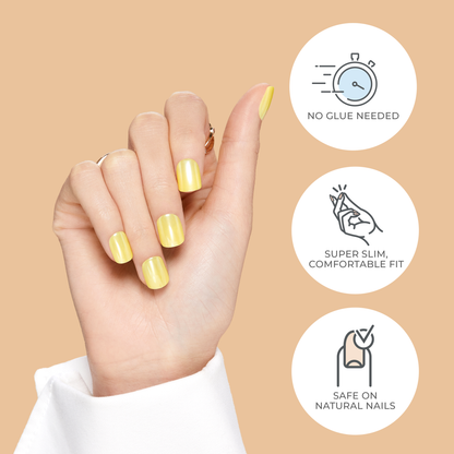 Hand with glossy yellow press-on nails shown against beige background, with icons stating no glue needed, super slim comfortable fit, and safe on natural nails.