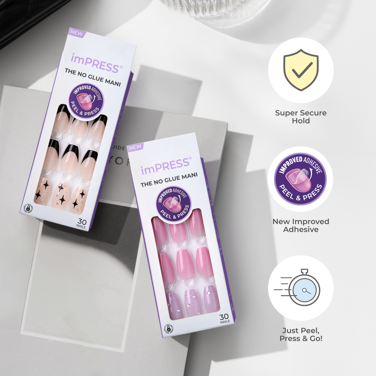 Two imPRESS press-on manicure boxes for wide fit nails, one with beige and black tips and star designs, the other with pink and purple nails with rhinestones. Both feature \