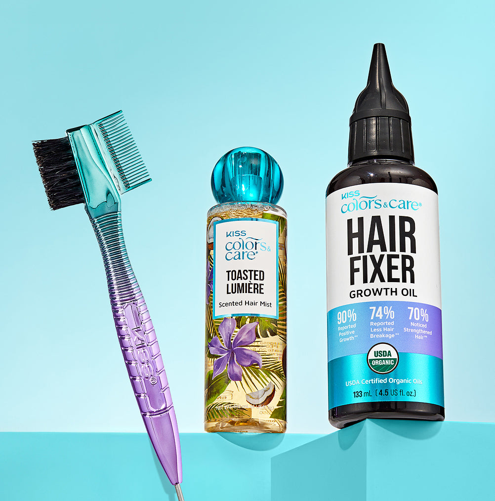 Hair care products including a brush, hair mist, and oil on a blue background