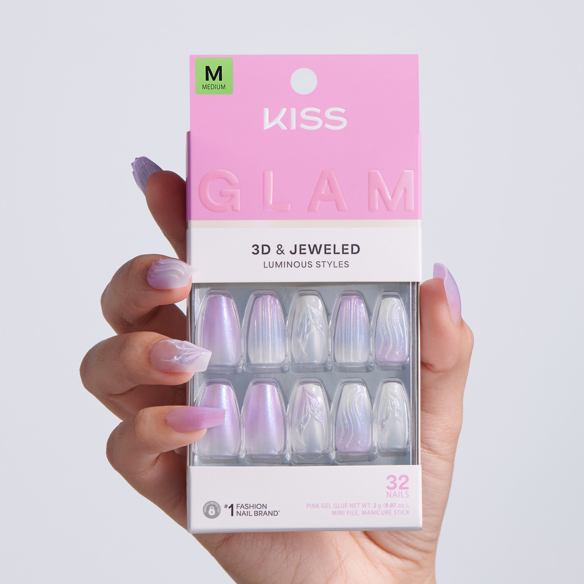 Kiss Glam 3D &amp; Jeweled nail art packaging held by a hand with purple nail polish.