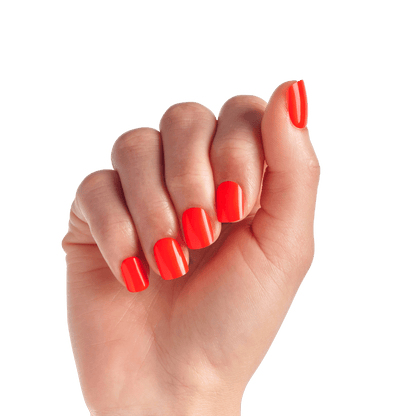 The image features a hand with neatly manicured nails painted in a vibrant shade of red. The fingers are slightly curled, showcasing the glossy finish of the nail polish. The background is plain white, which emphasizes the bold color of the nails. The overall appearance is stylish and eye-catching.