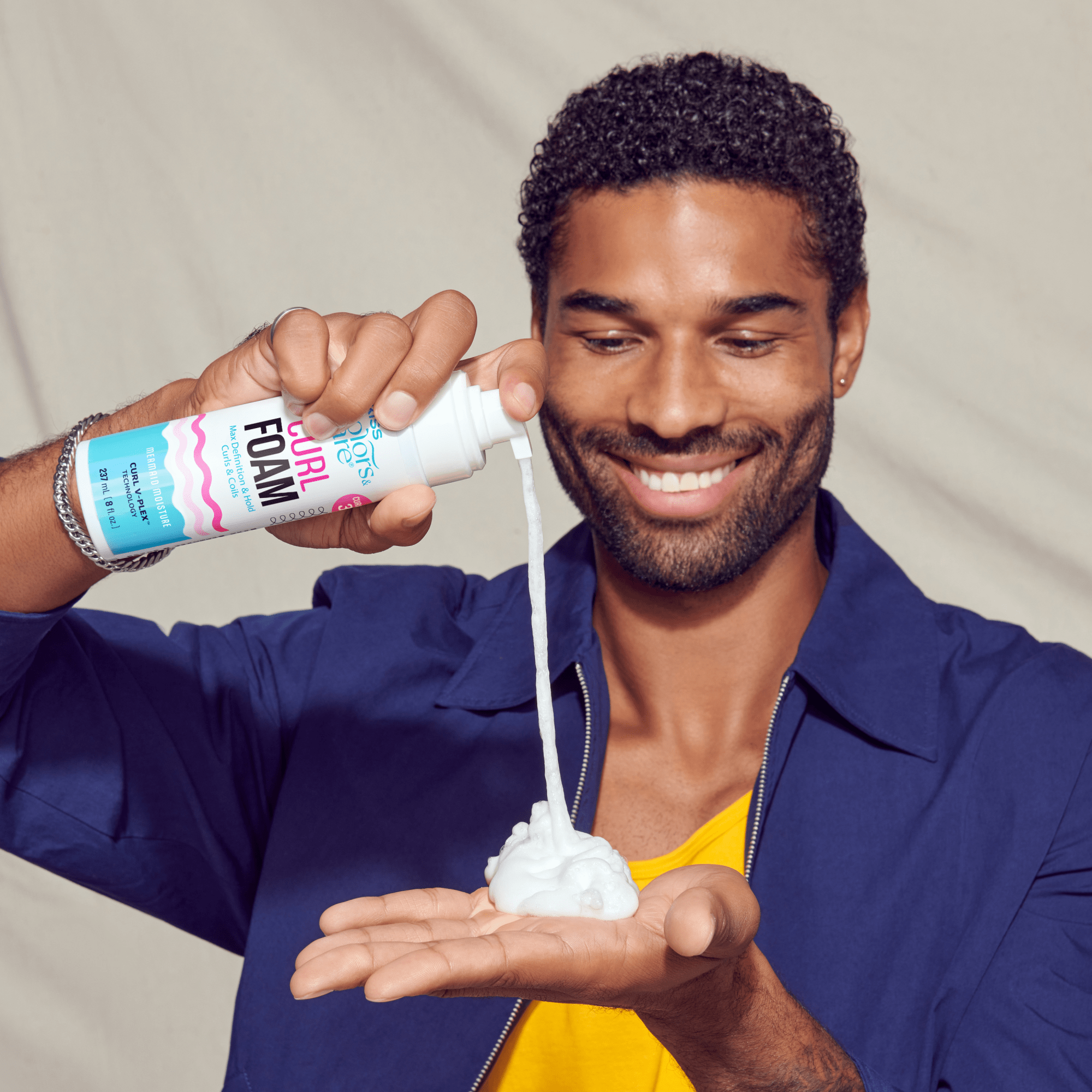 Man demonstrating curl foam hair product with foamy texture in hand
