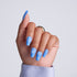 Hand with blue nail polish on a light gray background