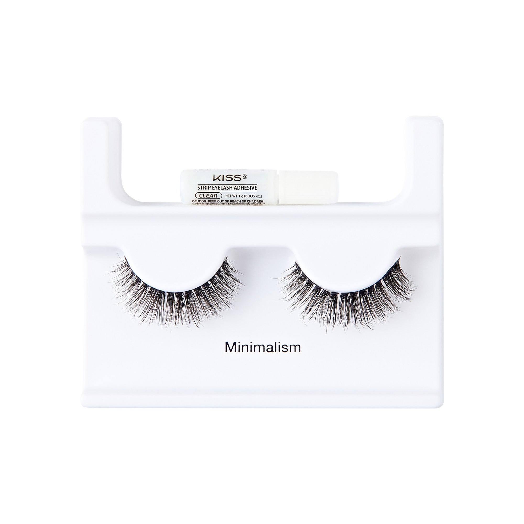 The image shows a set of false eyelashes displayed on a white holder. The holder has a minimalist design and features the word "Minimalism" printed on it. Above the eyelashes, there is a small tube of adhesive labeled "KISS Strip Lash Adhesive." The eyelashes are full and voluminous, with a natural-looking gradient from shorter to longer lashes. The overall presentation is clean and simple, emphasizing the minimalist theme.