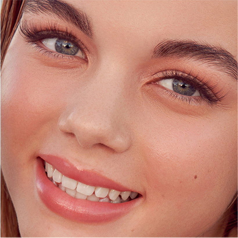 Close-up of woman's face showcasing KISS imPRESS Demi Edgy press-on nails and makeup.