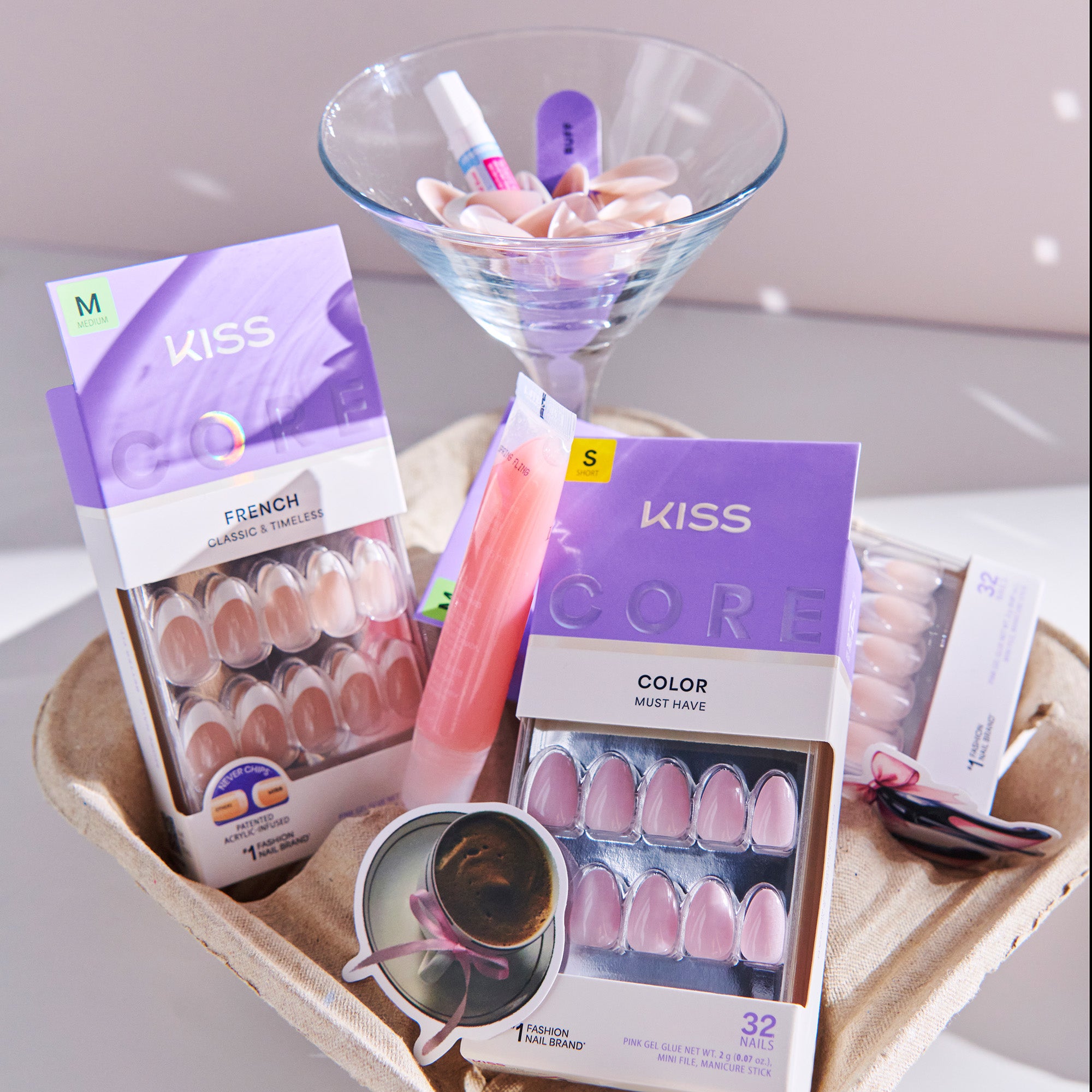 Kiss nail art products on a tray with a glass bowl containing additional items.