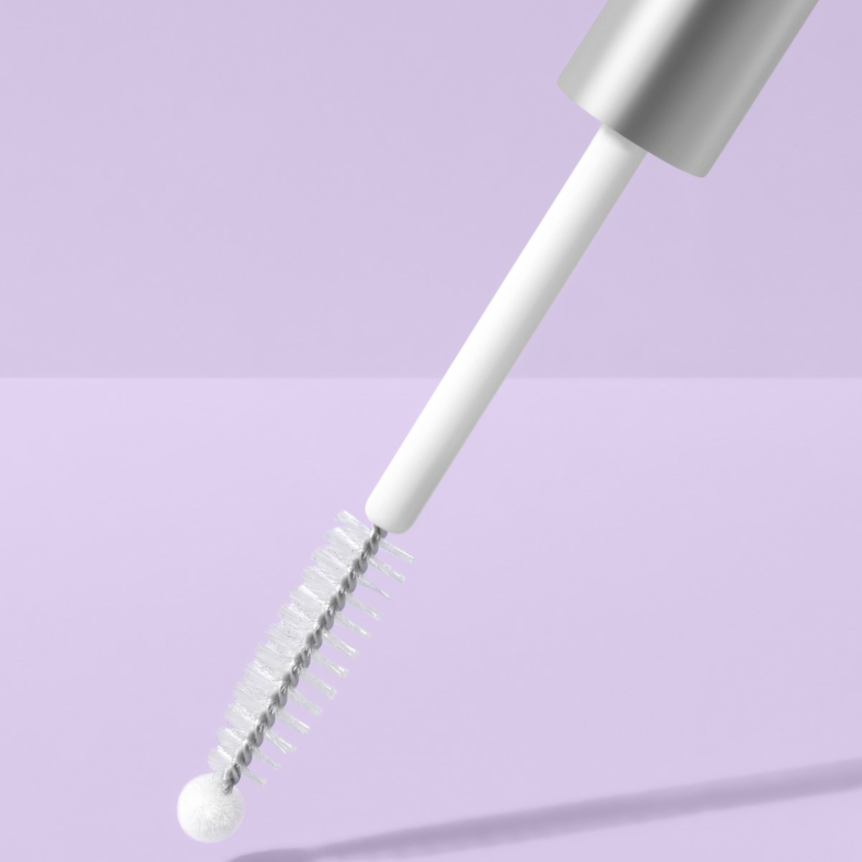 Eyelash extension brush with silver top on a light purple background