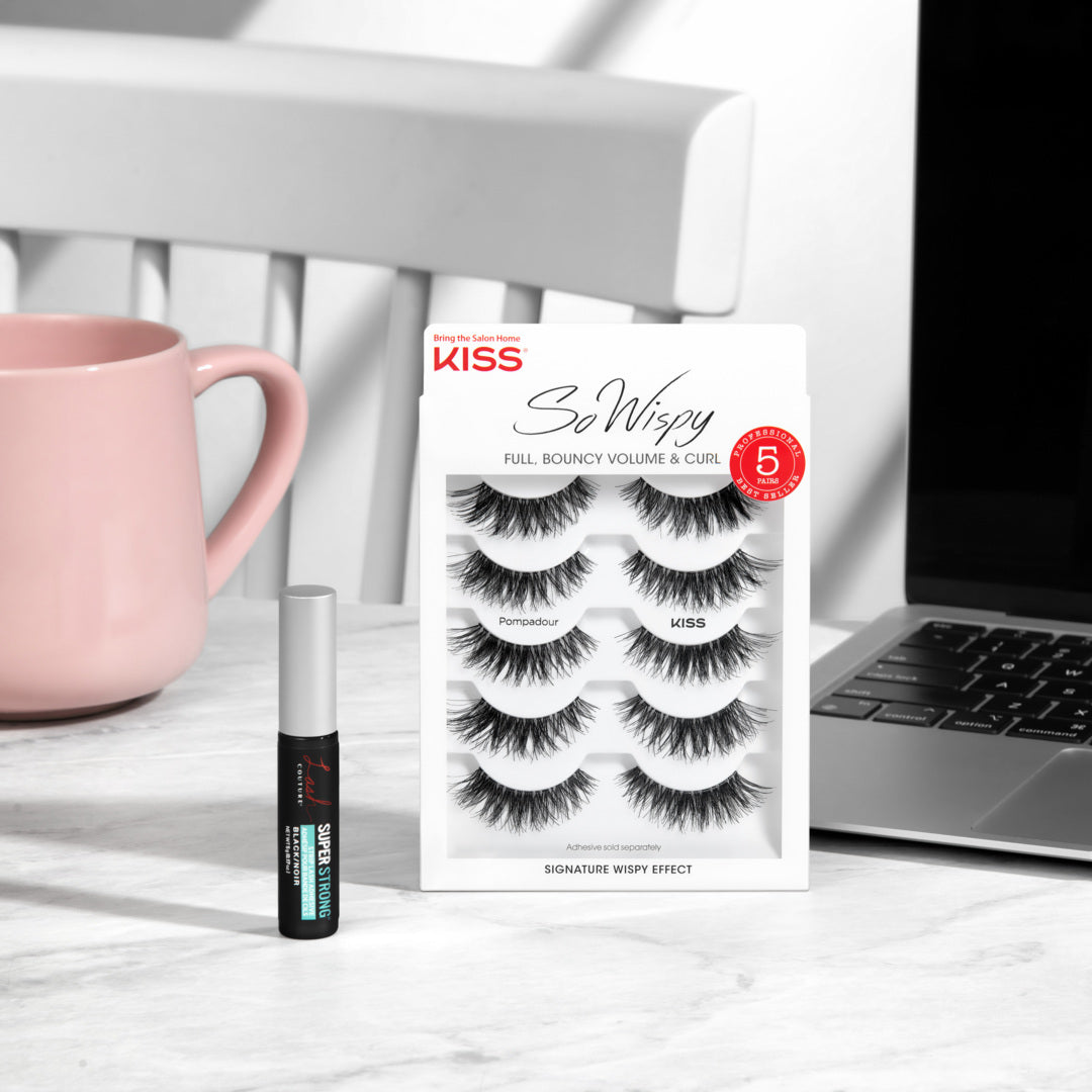Kiss So Wispy false eyelashes packaging with a mascara tube on a desk.