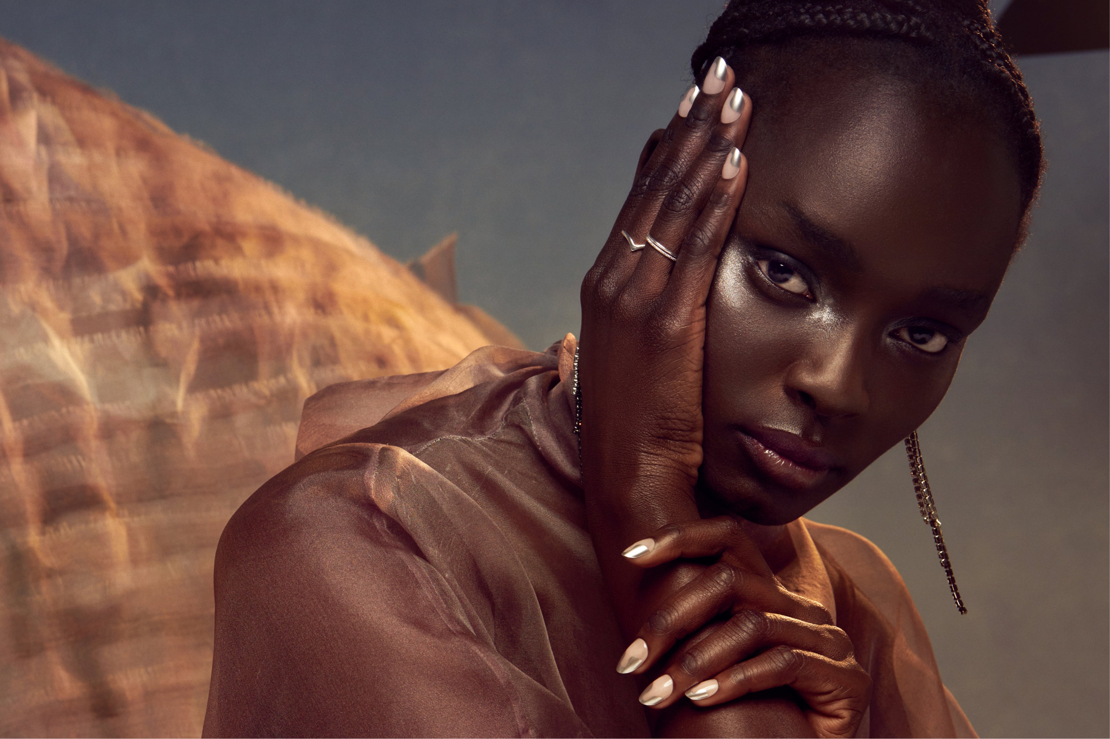 A woman modeling short silver tipped nails.