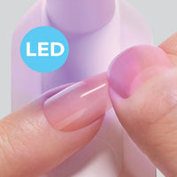 Close-up of artificial nail being held on natural nail while flash curing under the Kiss Salon X-tend LED lamp.