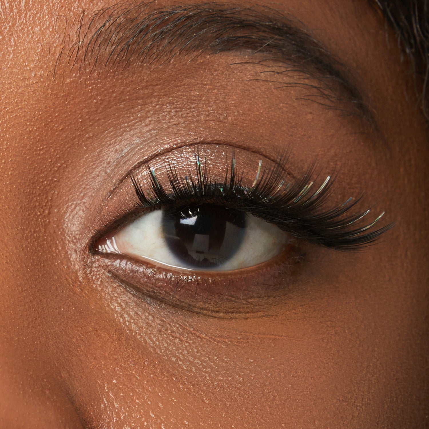 Close-up of eye with volumizing black mascara on warm-toned skin
