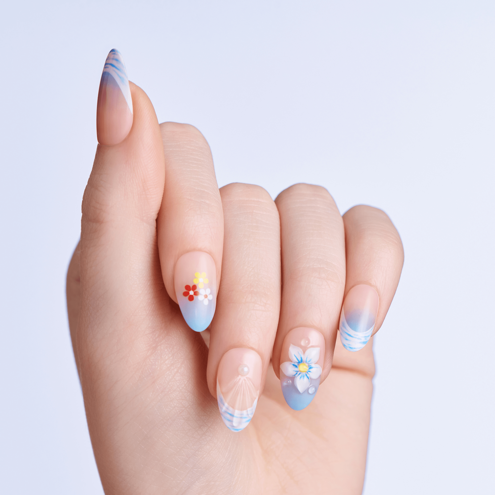 Hand with floral nail art on a light purple background