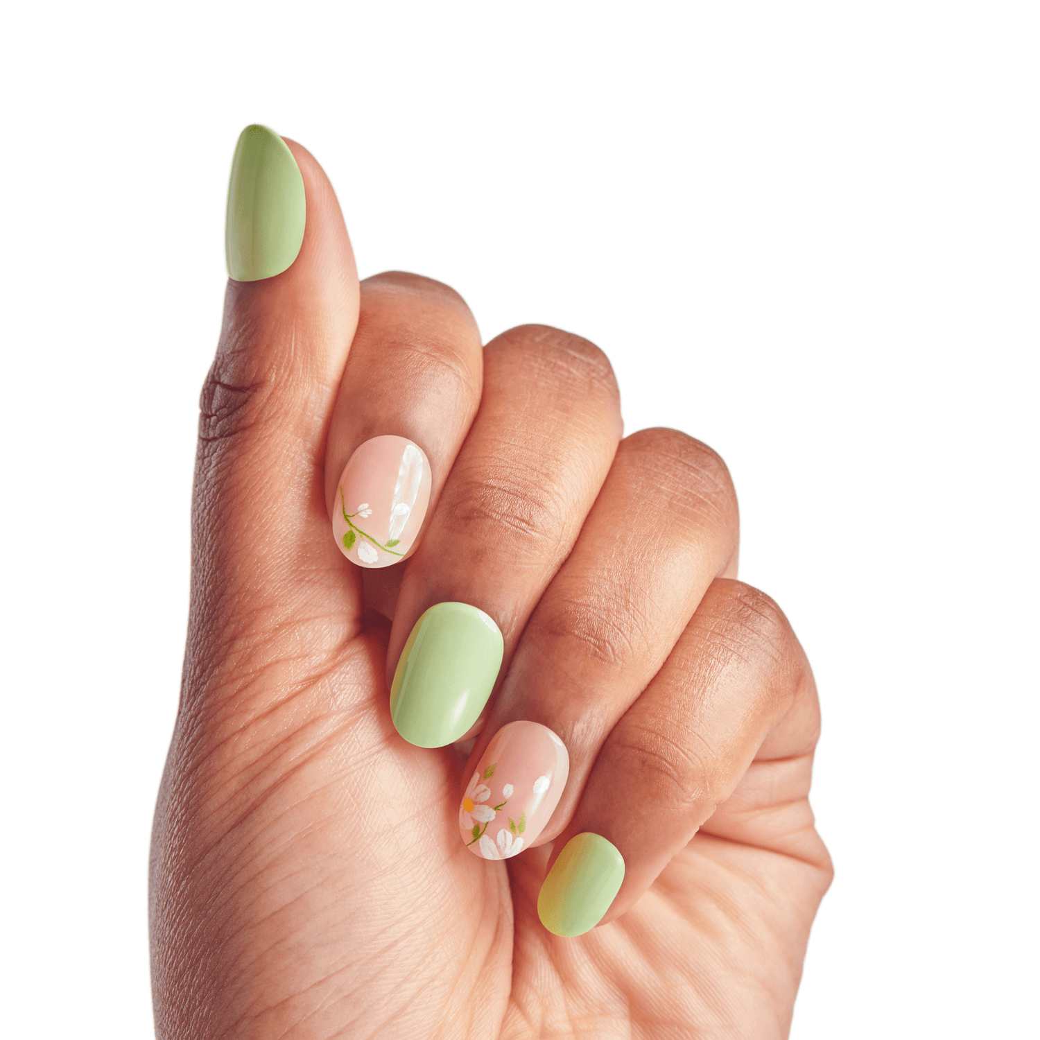 The image features a hand with manicured nails showcasing a stylish nail design. The nails are painted in a combination of soft green and a light peach color. The green nails are solid, while the peach nails have delicate floral patterns, adding a touch of elegance. The hand is positioned with fingers slightly curled, displaying the nail art prominently against a plain white background.