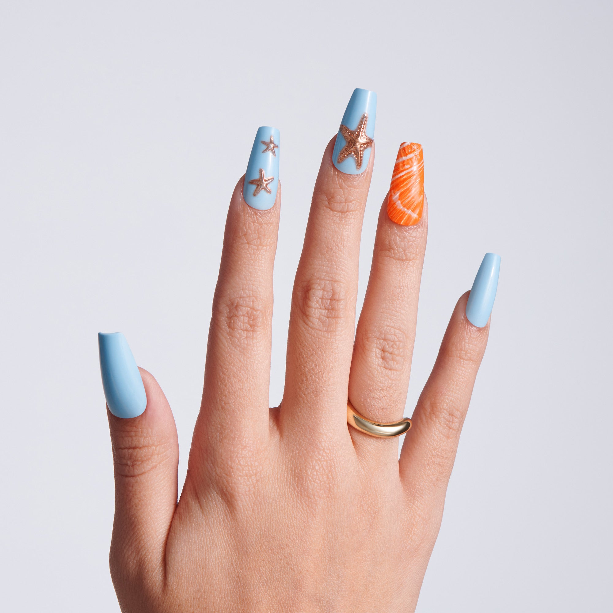 Hand with light blue nail polish featuring star designs on a plain background