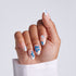 Hand with blue floral nail design on a light gray background
