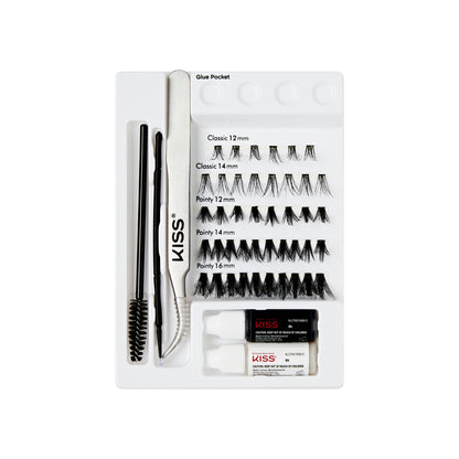The image features a neatly organized eyelash extension kit from the brand KISS. The kit includes various styles of false eyelashes, specifically labeled as "Classic" and "Pointy" in different lengths (12 mm, 14 mm, and 16 mm). There are two small tubes of adhesive glue, a pair of tweezers for application, and a spoolie brush for grooming. The items are arranged in a white tray with designated compartments, making it easy to access each component.