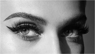 A black and white photo of a woman with long, dramatic eyelashes.