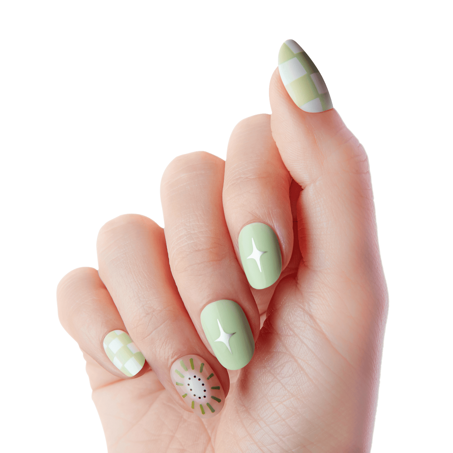 Hand with almond-shaped press-on nails in pastel green tones. Two nails feature white sparkles, two have a light green and white checkerboard pattern, and one has a kiwi fruit design with black seeds.