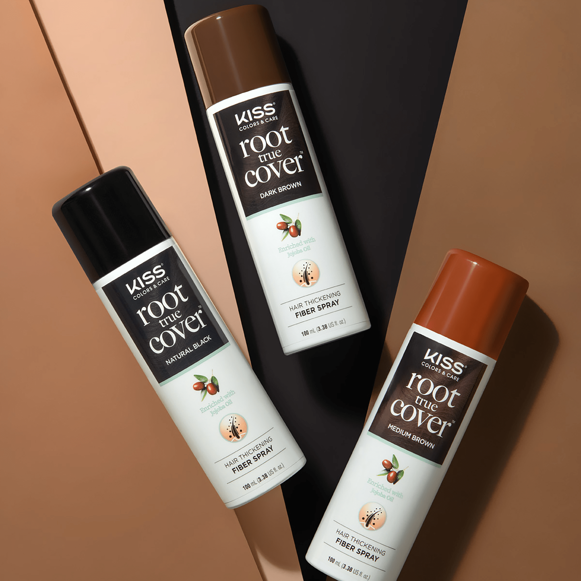 Three KISS Colors &amp; Care Root True Cover hair thickening fiber spray cans in Natural Black, Dark Brown, and Medium Brown, each labeled as enriched with jojoba oil.