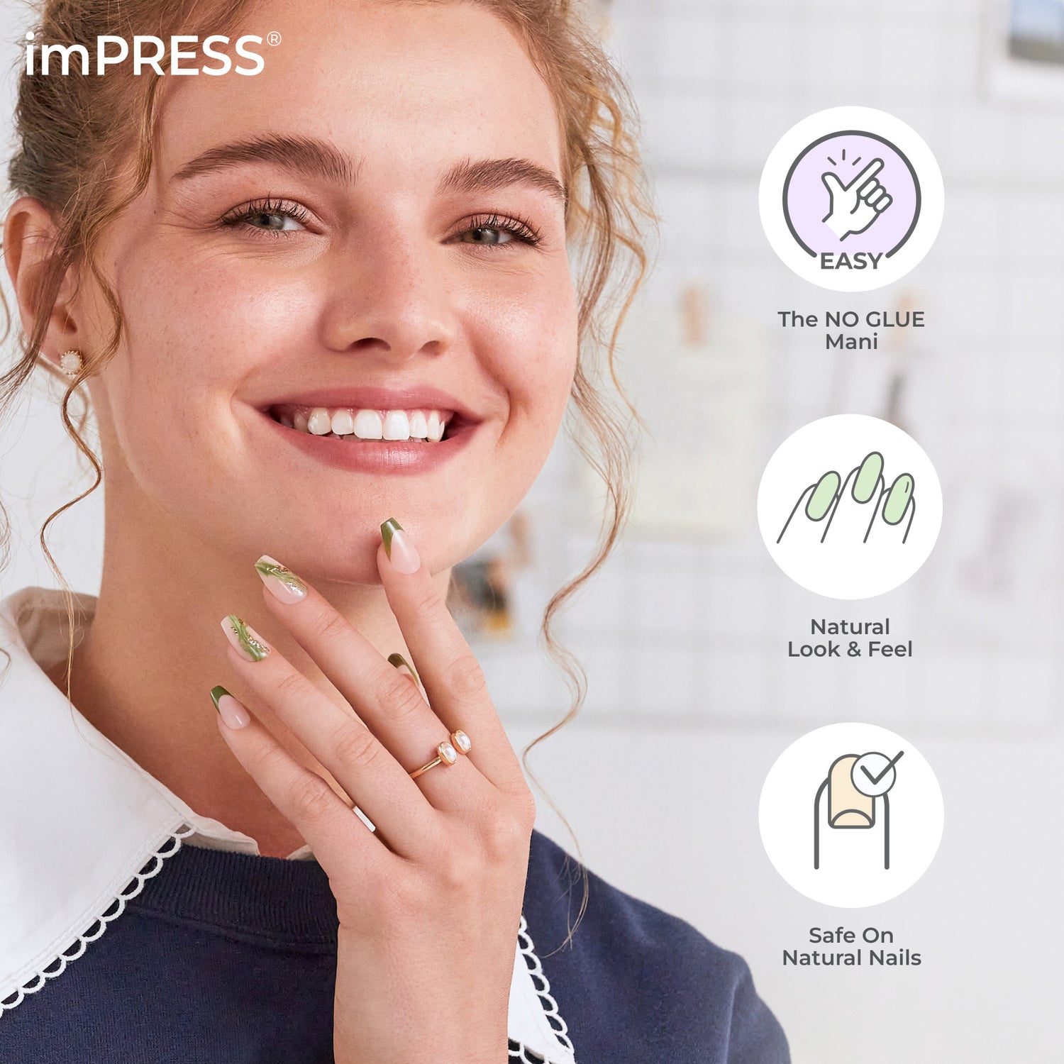 Smiling woman with green and nude press-on nails from imPRESS, holding her hand near her face; features easy, no-glue, natural look, and safe on nails.